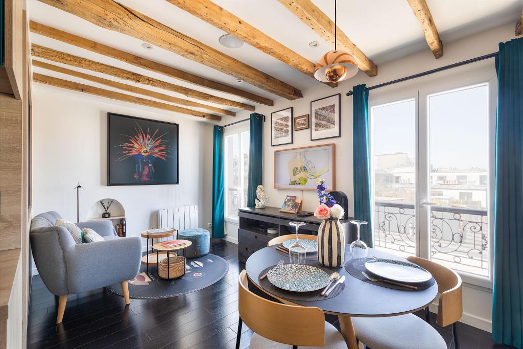 a living room with a table and a chair at Appartement avec vue panoramique in Paris