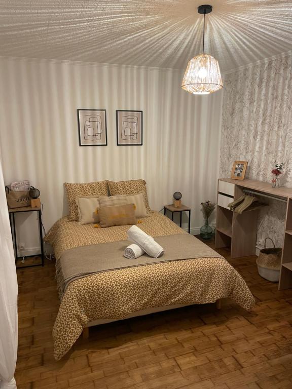 ein Schlafzimmer mit einem Bett mit zwei Handtüchern darauf in der Unterkunft Maison lumineuse, proche centre. in Châteauroux