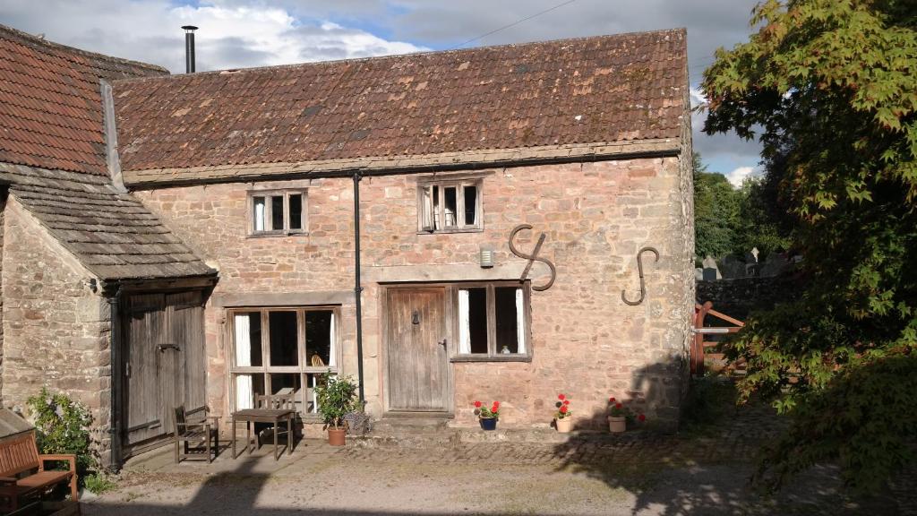 an old brick building with a wooden door at Historic cottage in the beautiful Wye Valley in Saint Briavels