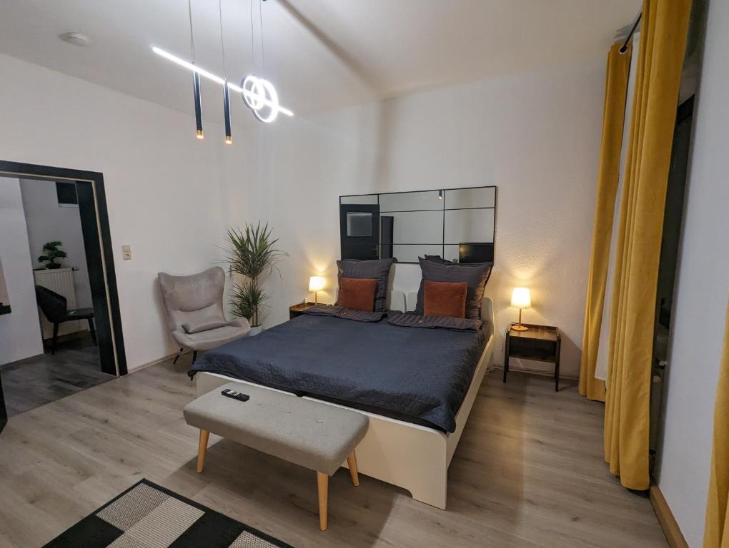 a bedroom with a large bed and a chair at Schönes 3 Zimmer Apartment in der Altstadt von Koblenz in Koblenz