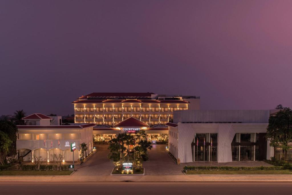 a large building with lights on it at night at Courtyard by Marriott Siem Reap Resort in Siem Reap
