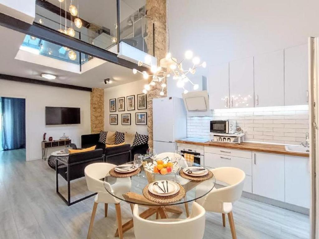 阿利坎特的住宿－LUXURY New Loft CITY CENTRE & Castle, Alicante，厨房以及带桌椅的起居室。