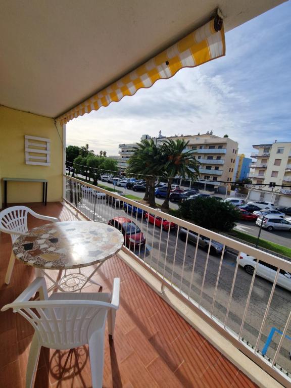 a balcony with a table and chairs and a view of a city at Beach Apartment Regueral in Cambrils