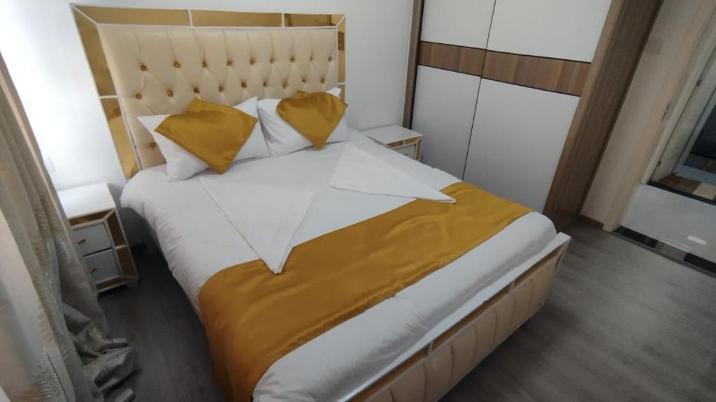 - une chambre avec un grand lit et des oreillers jaunes dans l'établissement Kalya's Goldpark Stays, à Nairobi
