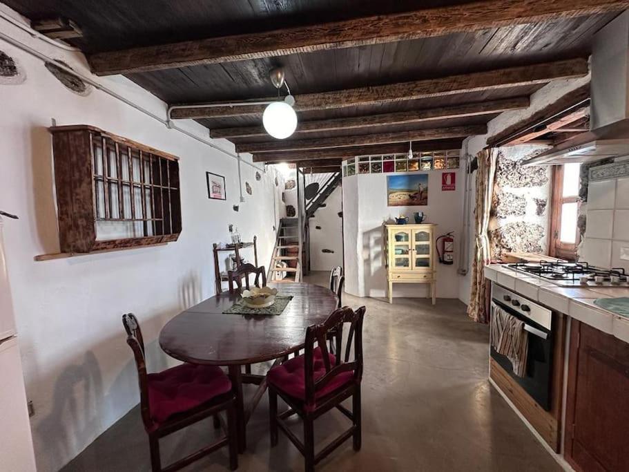 eine Küche mit einem Tisch und Stühlen im Zimmer in der Unterkunft Casa Poesía de El Hierro, situada en el centro de El Pinar in El Pinar del Hierro