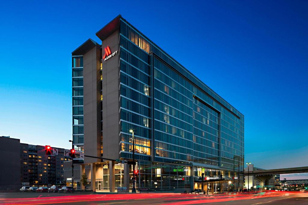 a large glass building on a city street at night at Omaha Marriott Downtown at the Capitol District in Omaha