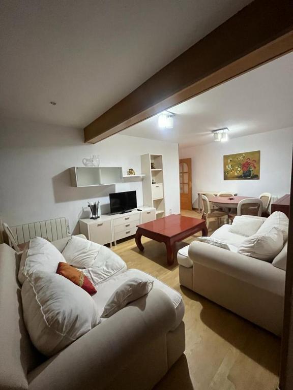 una sala de estar con 2 sofás blancos y una mesa. en SAPORO ELITE, en Sierra Nevada