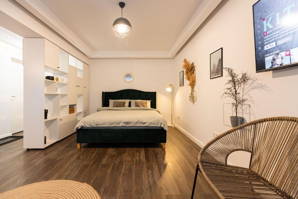 um quarto com uma cama e 2 cadeiras em Ultra central apartment em Baia Mare