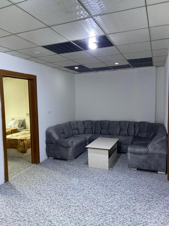 Zirka Apartments Duhok في دهوك: غرفة معيشة مع أريكة وطاولة