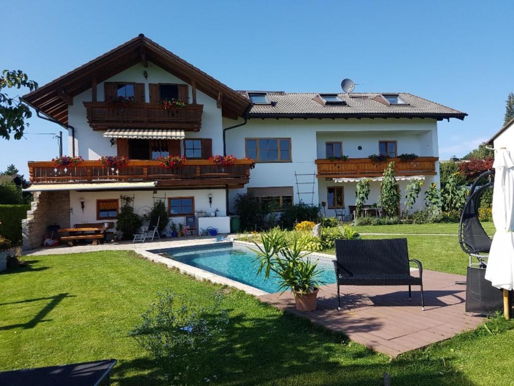 una casa con piscina frente a ella en Ferienwohnung Lorenz, en Heufeld