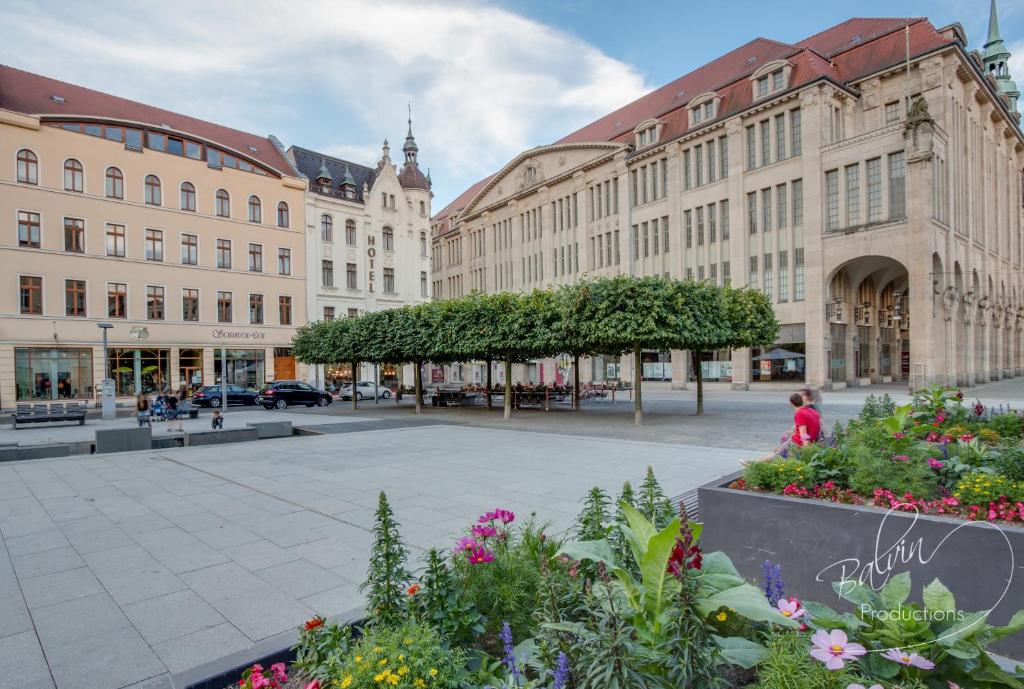 una calle en una ciudad con edificios y flores en Akzent Hotel Am Goldenen Strauss, en Görlitz