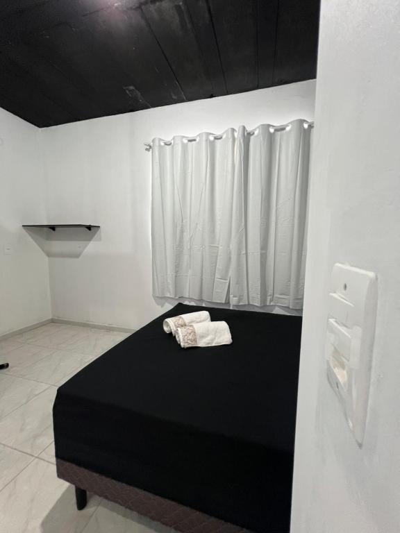 1 dormitorio con cama negra y ventana en Suite 1- black em Praia bonita hospedagem, en São Francisco do Sul