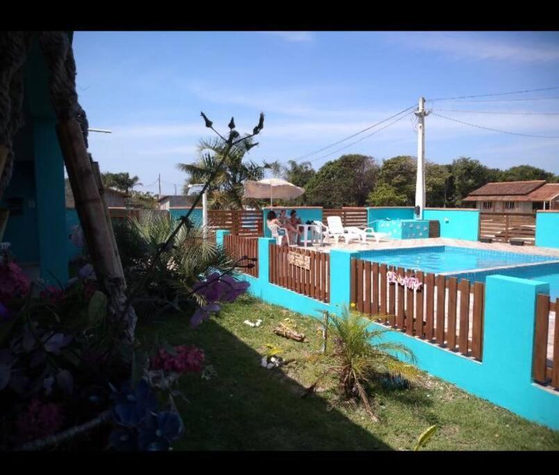 una casa azul con piscina en un patio en Pousada Luzemar flat, en São Francisco do Sul