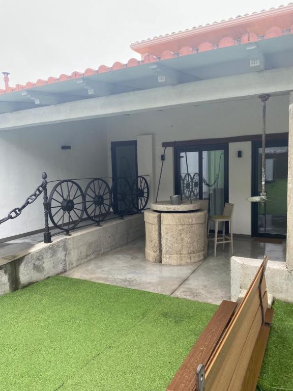 eine Terrasse mit einem Rasenhof und einem Gebäude in der Unterkunft Barraña Guest House in Boiro