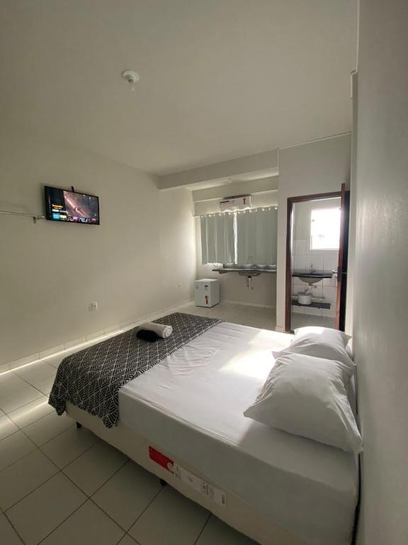 Un dormitorio con una cama grande en una habitación. en Infinit Hotel Flats, en Janaúba
