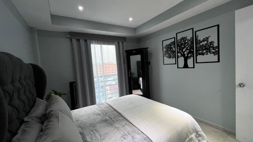 een slaapkamer met een bed met twee foto's aan de muur bij Private Penthouse / Penthouse Privado in Mexico-Stad