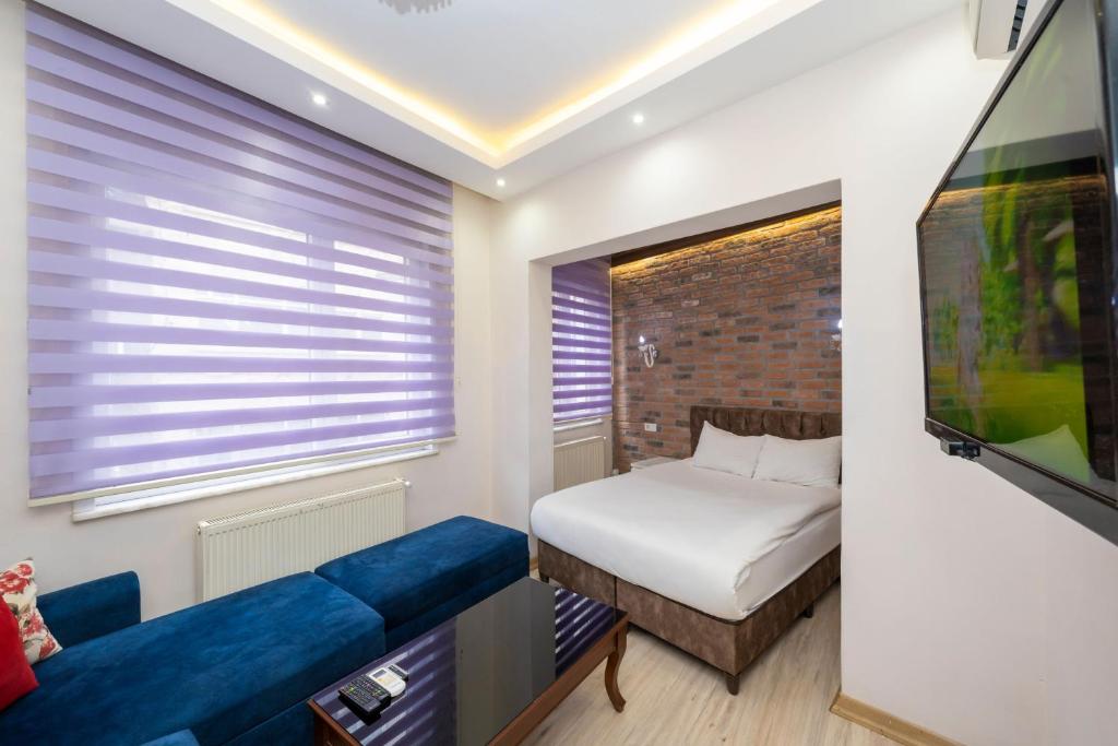a small bedroom with a bed and a tv at Taksim City Suite in Istanbul