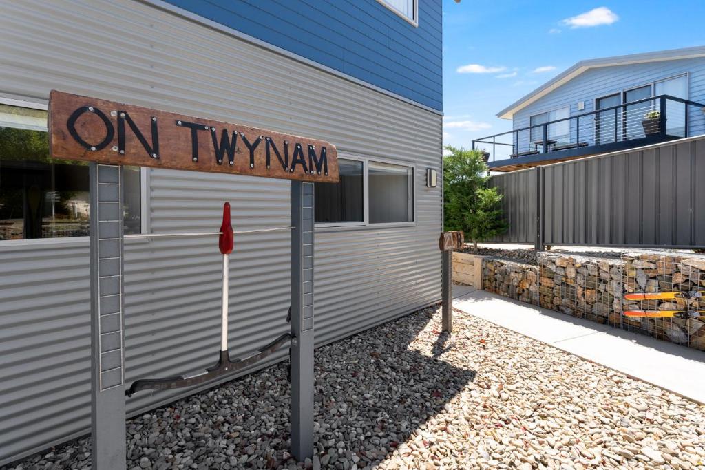 an on thy way sign in front of a building at T Bar on Twynam - Modern 2BR Apartment l WiFi l Netflix l BBQ l Smart TV l Air-Con in Jindabyne