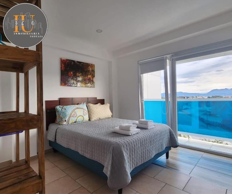 1 dormitorio con cama y ventana grande en Josefina 4D en Ushuaia