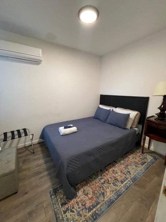 1 dormitorio con cama con sábanas azules y alfombra en Point Breeze South Philly (2 bedrooms), en Filadelfia