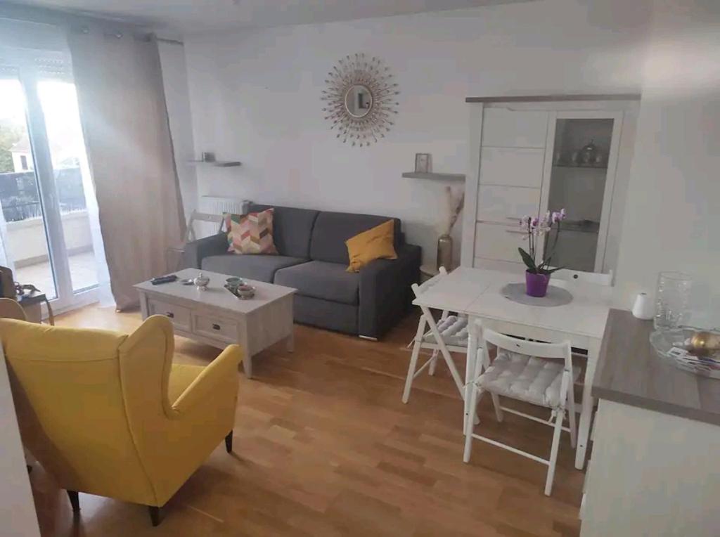 uma sala de estar com um sofá e uma mesa em Logement à côté de l'aéroport Orly em Athis-Mons