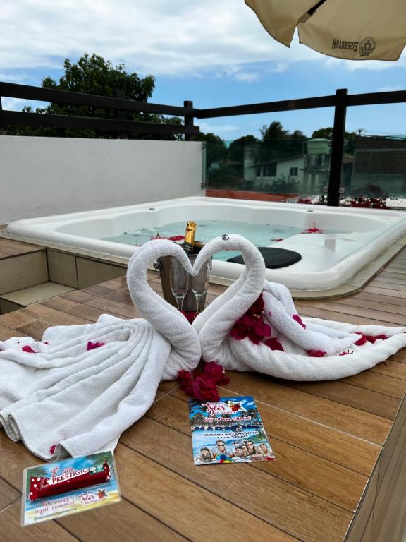 two swans wrapped in towels sitting on a deck at Pousada Flor de Maraca in Porto De Galinhas