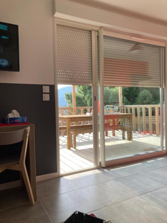 a living room with a sliding glass door with a table at B&B Macchia Verdata avec piscine in Monacia-dʼAullène