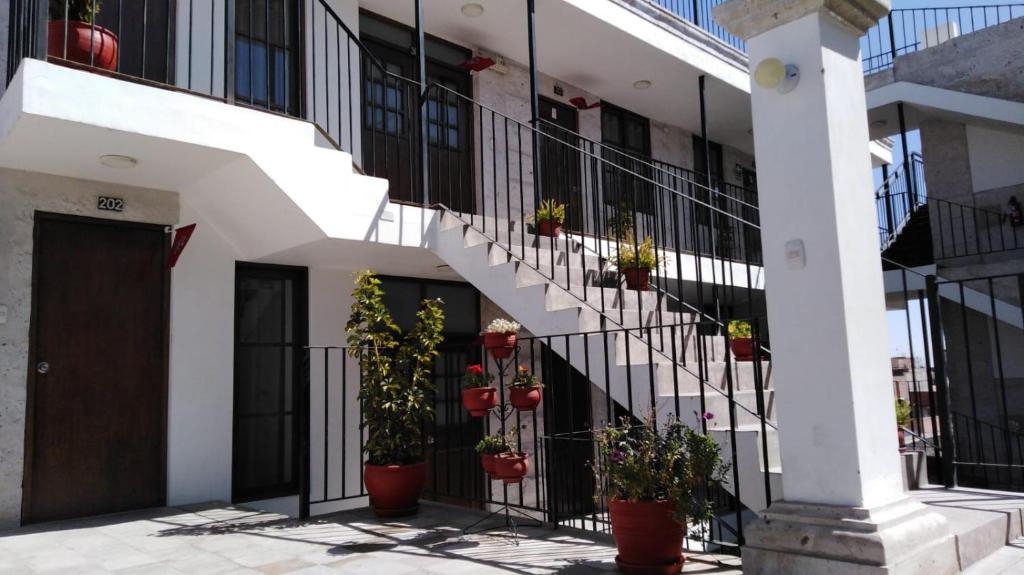 a building with stairs and potted plants on it at Hotel Mutua FAP in Arequipa