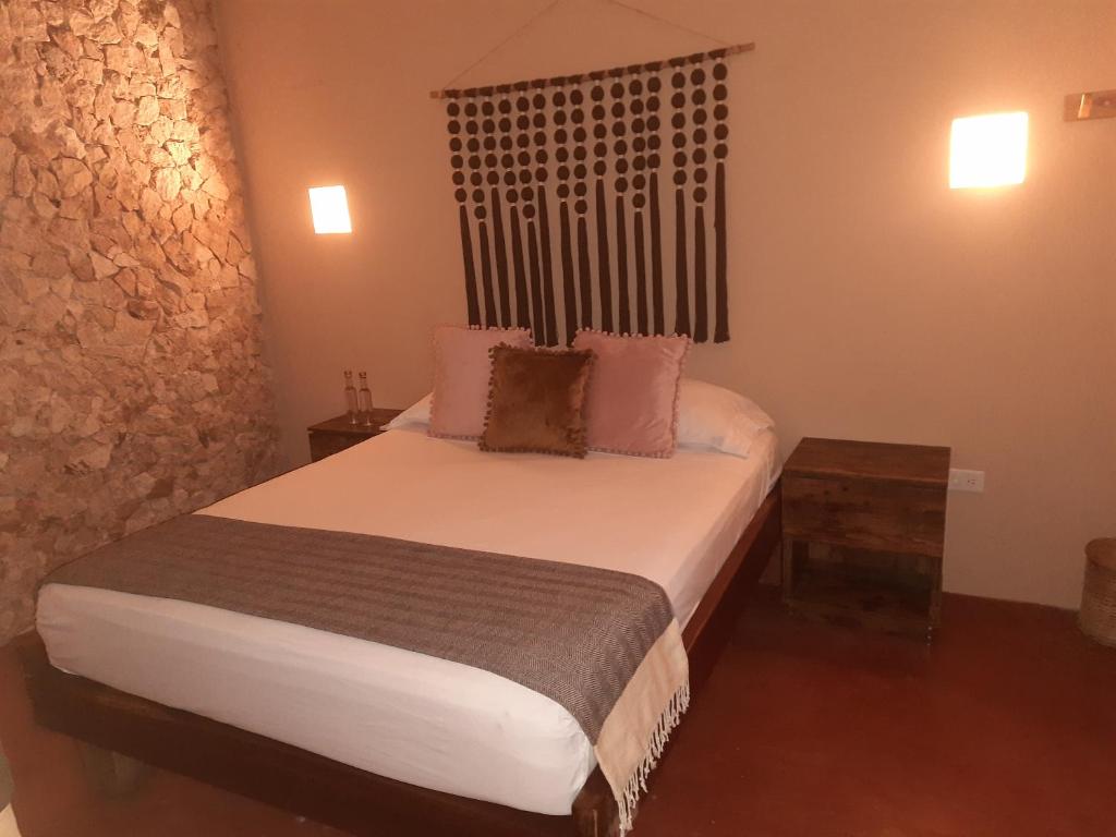 a bedroom with a large bed with a wooden headboard at Hotel Boutique Refugio 41 in Valladolid