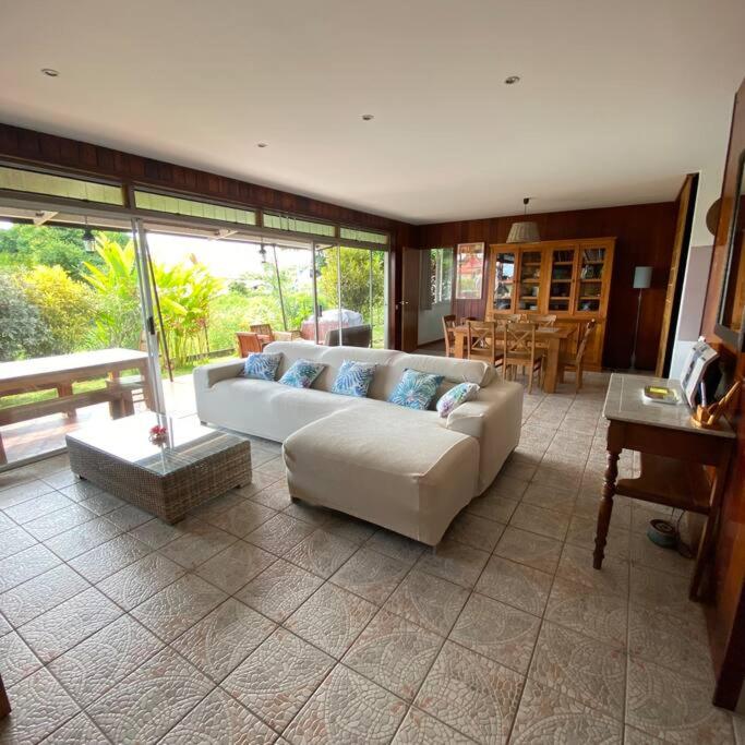 a living room with a couch and a table at Tahitian villa avec accès mer privé à 300 m in Punaauia