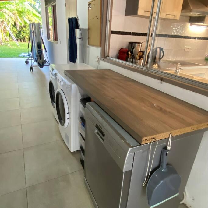 a kitchen with a sink and a washing machine at Tahitian villa avec accès mer privé à 300 m in Punaauia