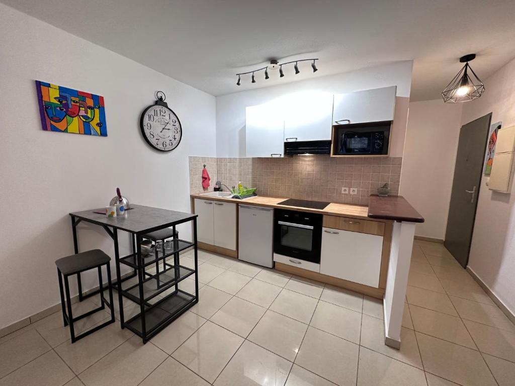 a kitchen with a counter and a table in it at Studio Bellepierre in Saint-Denis