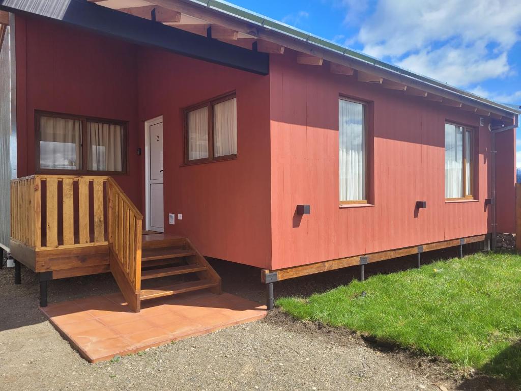 a red house with a staircase and a porch at Complejo Puente viejo casa 2 in Trevelin