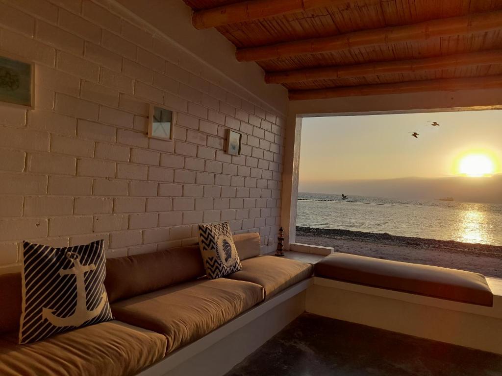 Chalets Paracas في باراكاس: أريكة في غرفة مطلة على المحيط