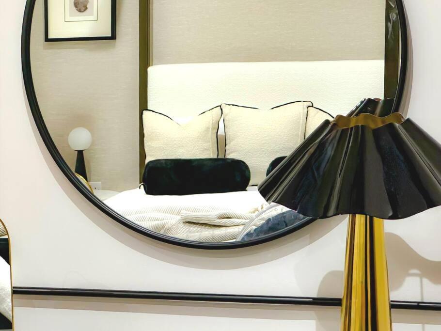 a mirror reflecting a bedroom with a bed in it at Luxury, Interior-Designed, Spacious Home in Harrogate