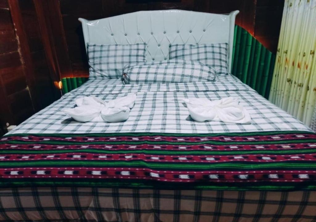 Una cama con dos pares de zapatos encima. en Villa Bamboo Bujak Permai, en Praya