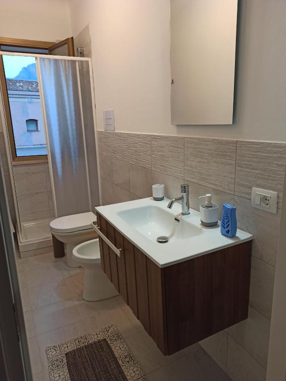 Un baño con lavabo, inodoro y espejo. en A casa di nonna Maria, en Terrasini