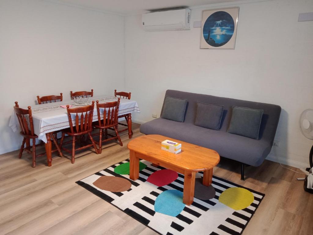 uma sala de estar com um sofá e uma mesa em Batemans Bay 2-bedroom gem newly renovated em Batemans Bay