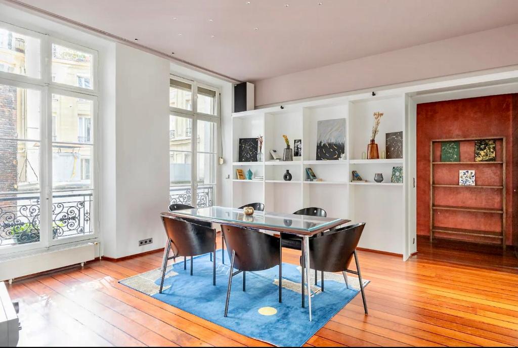 a dining room with a table and chairs at Chic Parisian Flat in Paris