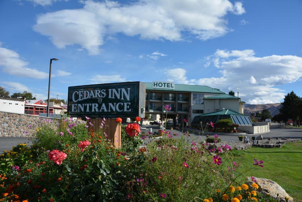 a sign in front of a hotel with flowers at Cedars Inn in Wenatchee