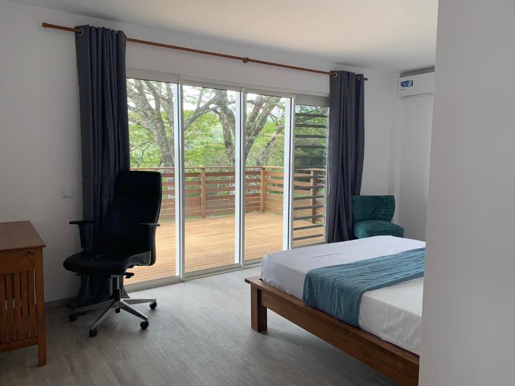 a bedroom with a bed and a desk and a chair at Puunui Lodge in Vairao