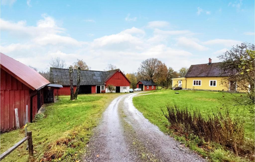 a dirt road through a farm with red and yellow buildings at Nice Home In Torup With Wifi in Torup