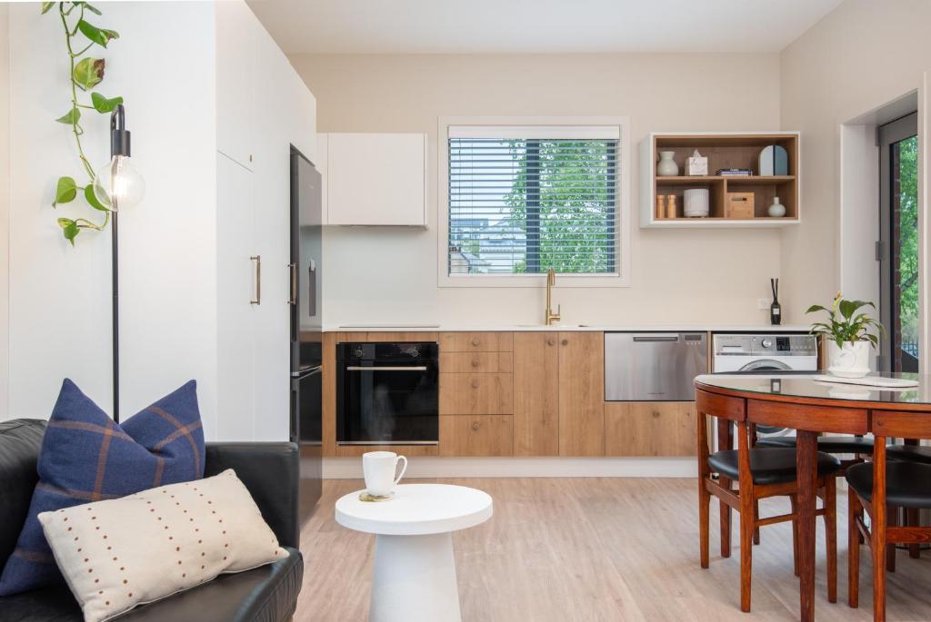 uma cozinha e sala de estar com um sofá e uma mesa em George Little em Dunedin