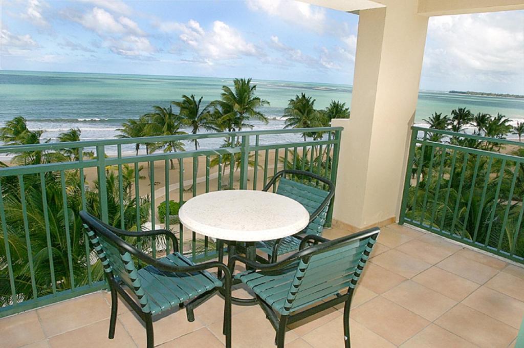 リオ・グランデにある1 bedroom beachfront Apartment at Rio Marの海を望むバルコニー(テーブル、椅子付)