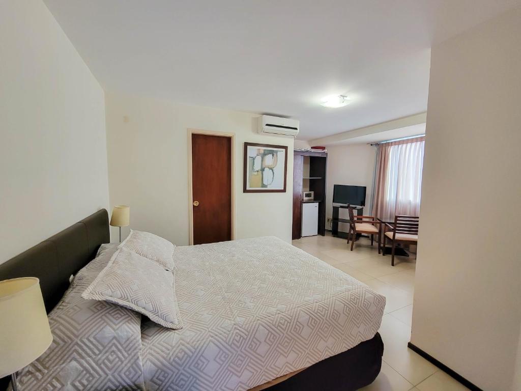 1 dormitorio con 1 cama y sala de estar en Hotel Genoves, en Piriápolis