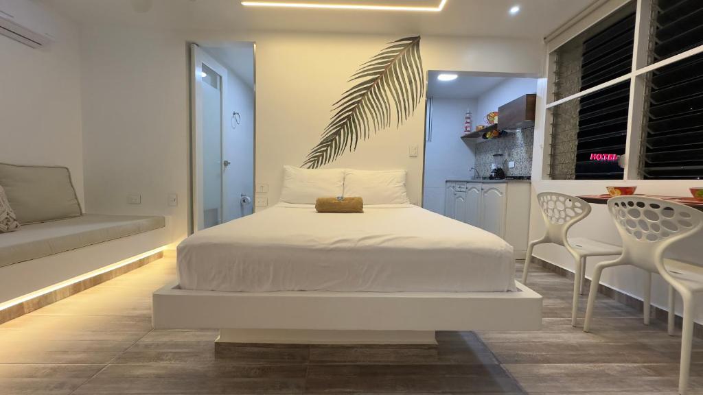 a bedroom with a white bed and a table and chairs at El Morro Beach 2 in Santa Marta