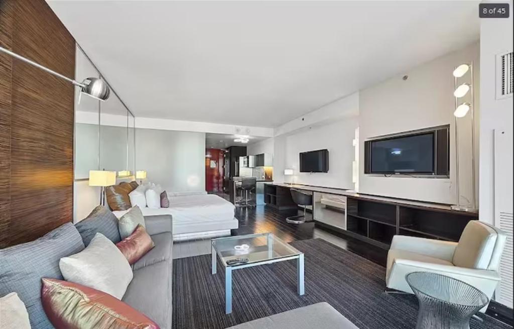 a living room with a couch and a tv at Luxury Hotel Suite With Private Strip View Balcony in Las Vegas