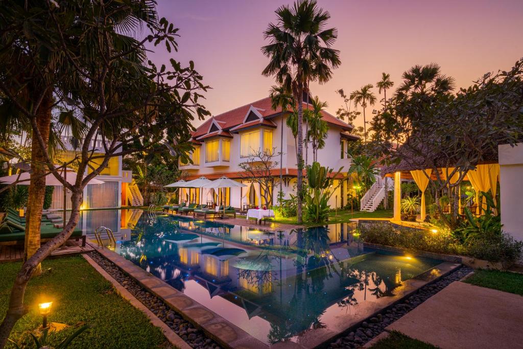 una vista exterior de una villa con piscina en The Embassy Angkor Resort & Spa en Siem Reap