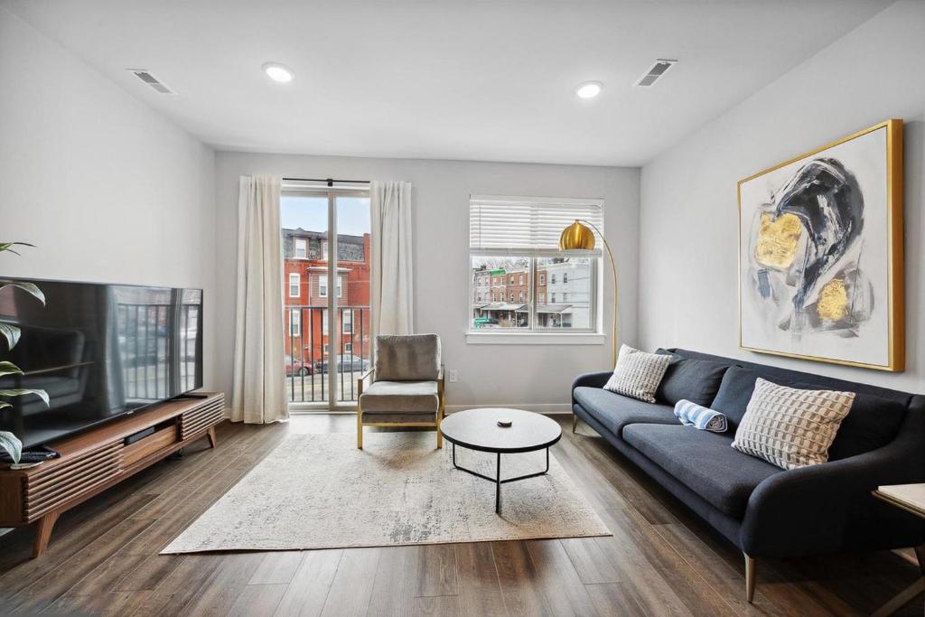 a living room with a couch and a tv at Luxurious Condo with Rooftop and Parking near University City in Philadelphia