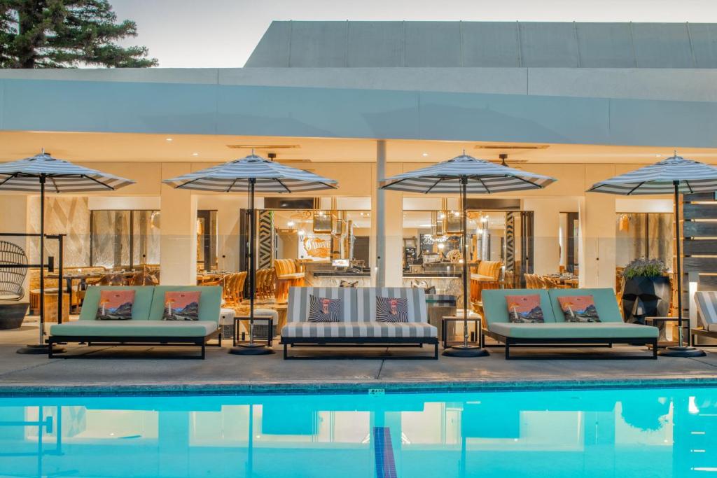 - un groupe de chaises longues et de parasols à côté de la piscine dans l'établissement Hotel Paradox, Autograph Collection, à Santa Cruz